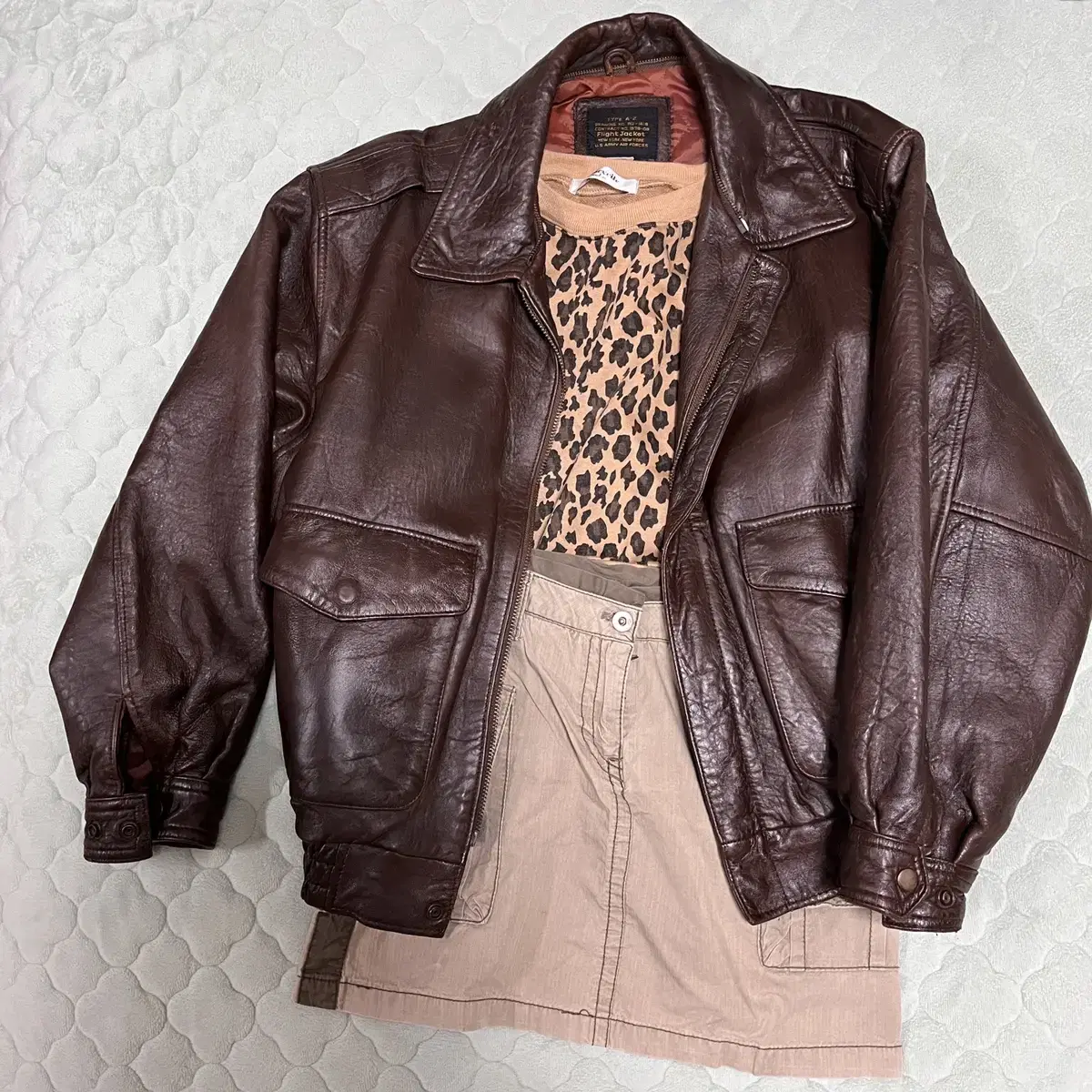 Discount on a set of a vintage leather jacket, cargo skirt, and leopard-print sweatshirt