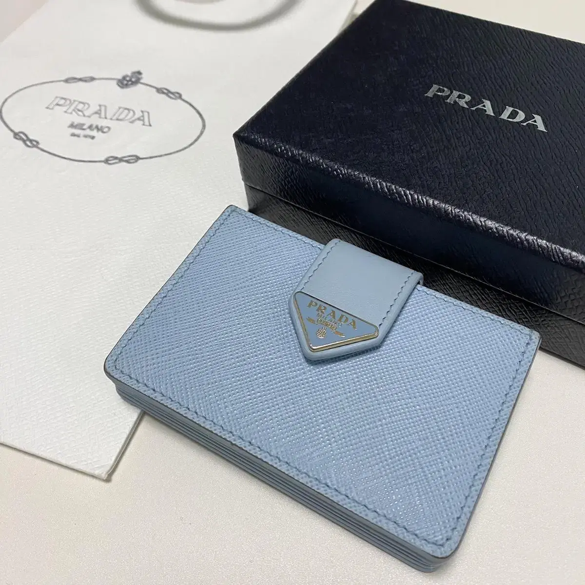 프라다 prada 아코디언 사피아노 가죽 똑딱이 카드지갑 라이트블루