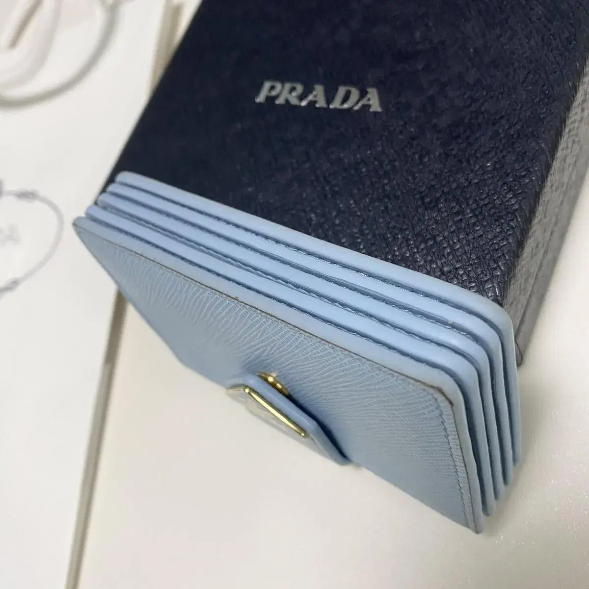 프라다 prada 아코디언 사피아노 가죽 똑딱이 카드지갑 라이트블루