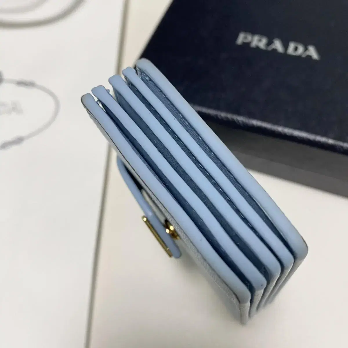 프라다 prada 아코디언 사피아노 가죽 똑딱이 카드지갑 라이트블루