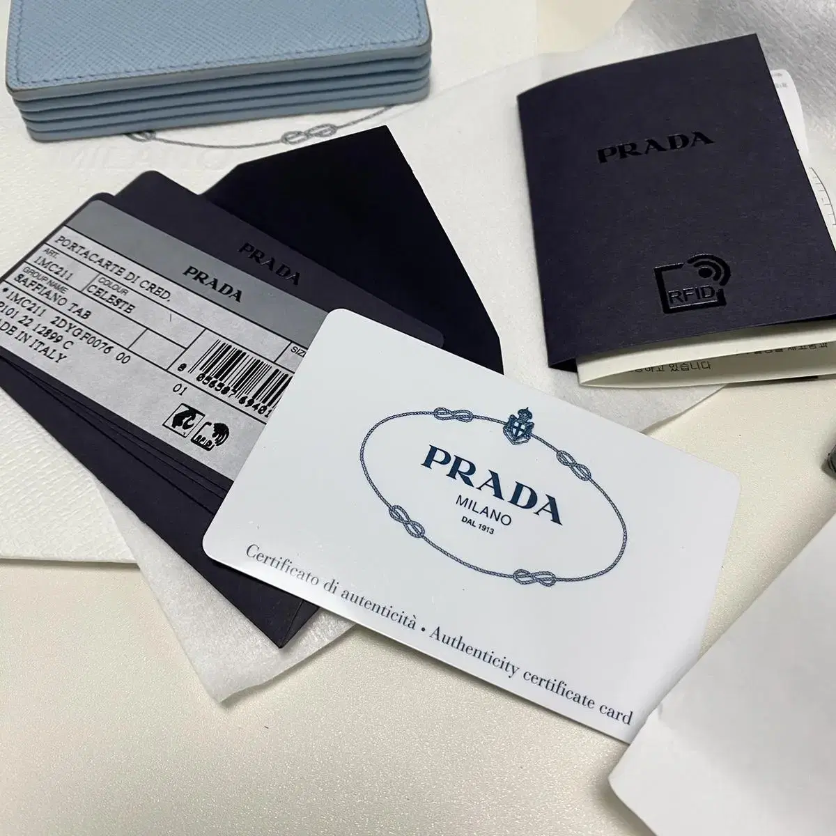 프라다 prada 아코디언 사피아노 가죽 똑딱이 카드지갑 라이트블루