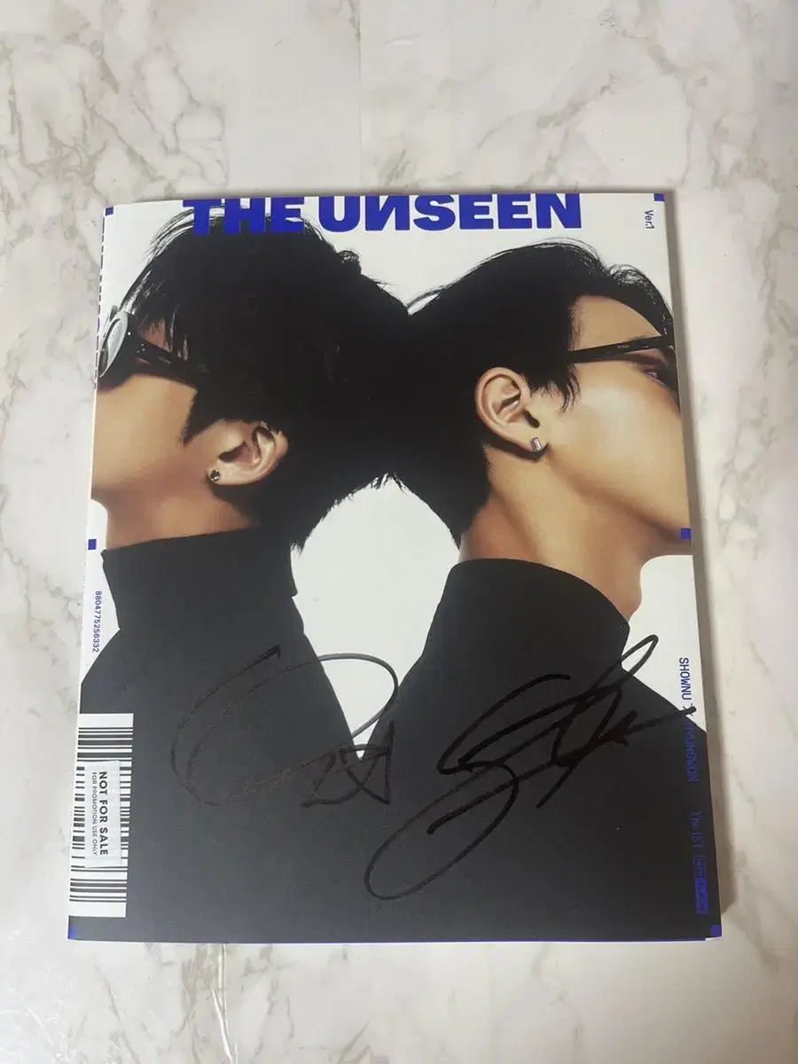 The unsealed album of The unseen signed by Hyungwon & Shownu.