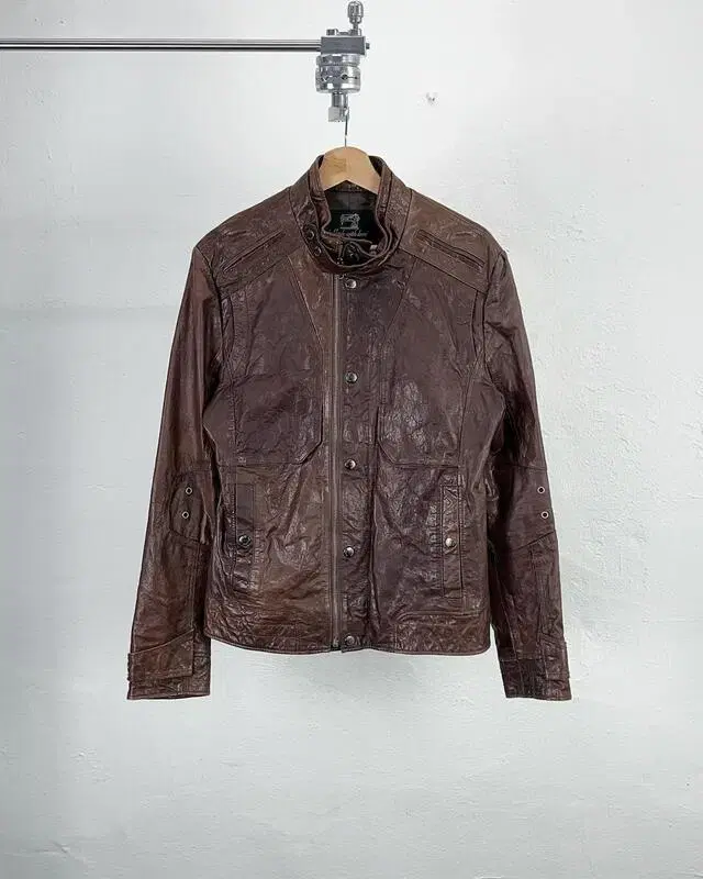 Brown glossy zip-button mix shearling jacket by Garth Jins