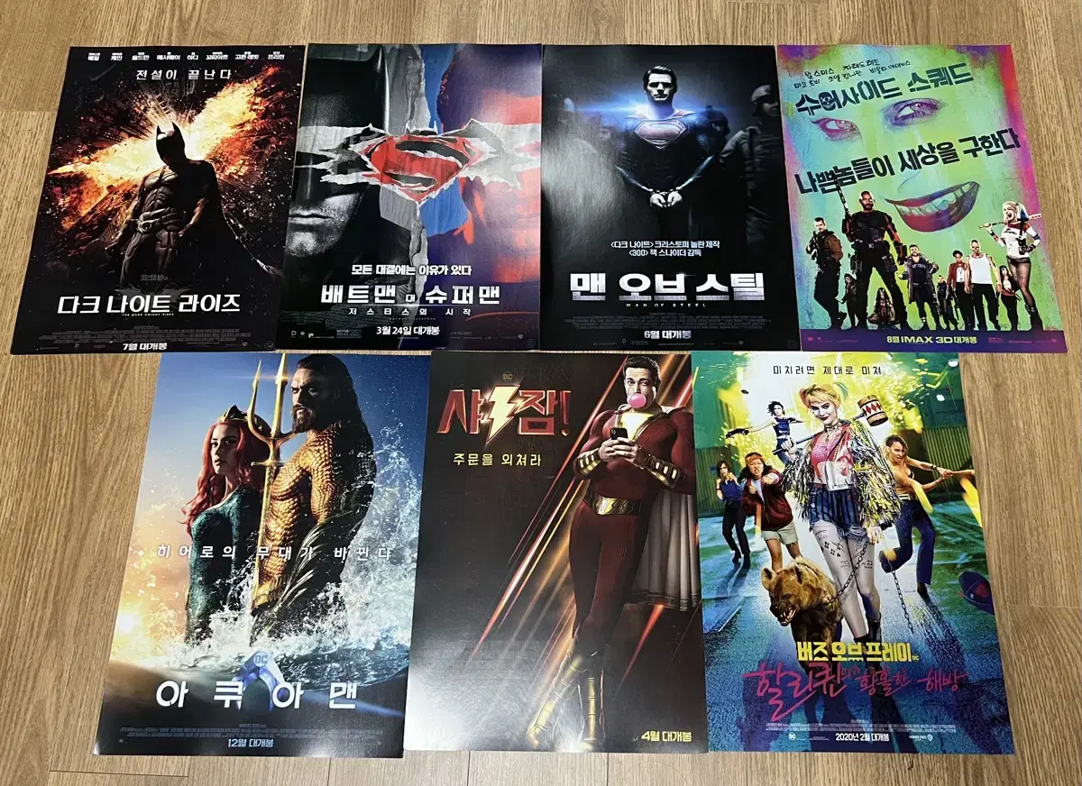 Movies poster sells seven DC Cinematic Universe pamphlets.