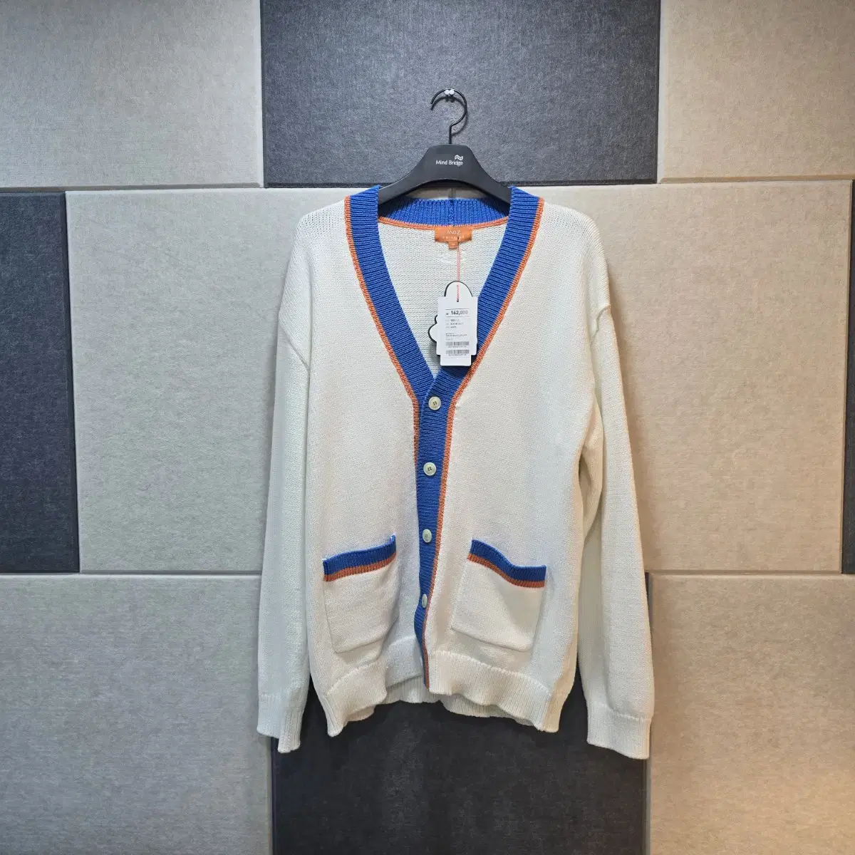 Bloo. White cardigan with orange trim.