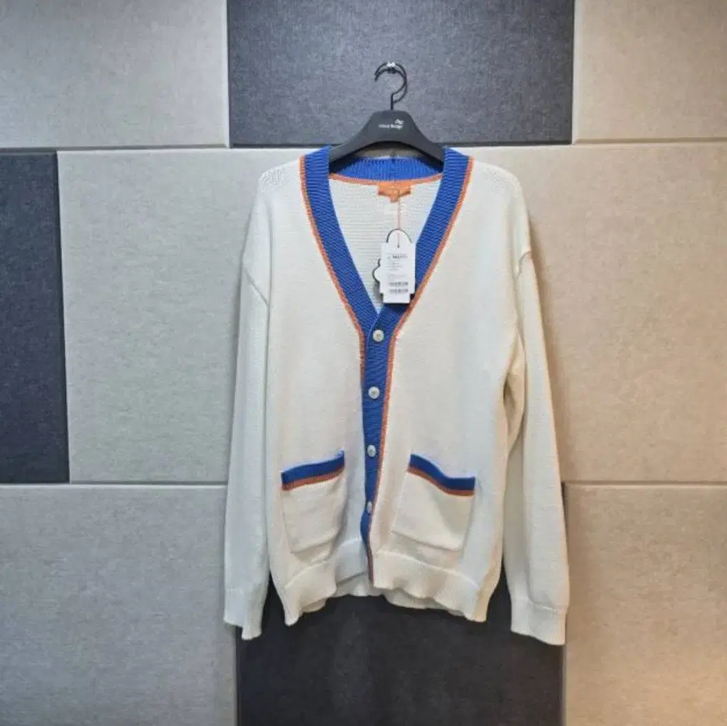 Bloo. White cardigan with orange trim.