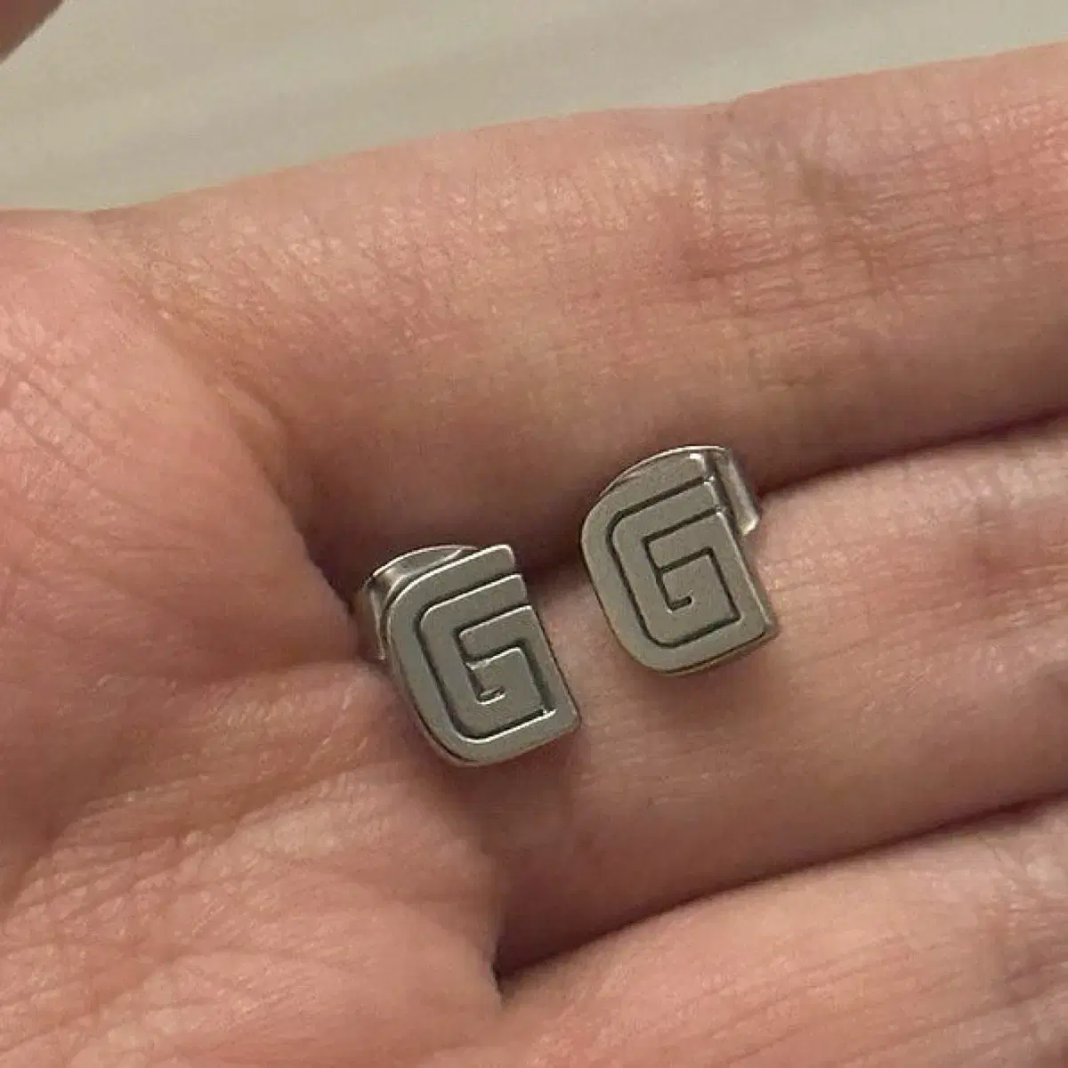 글로니 귀걸이 GLOWNY G SYMBOL EARRINGS SILVER