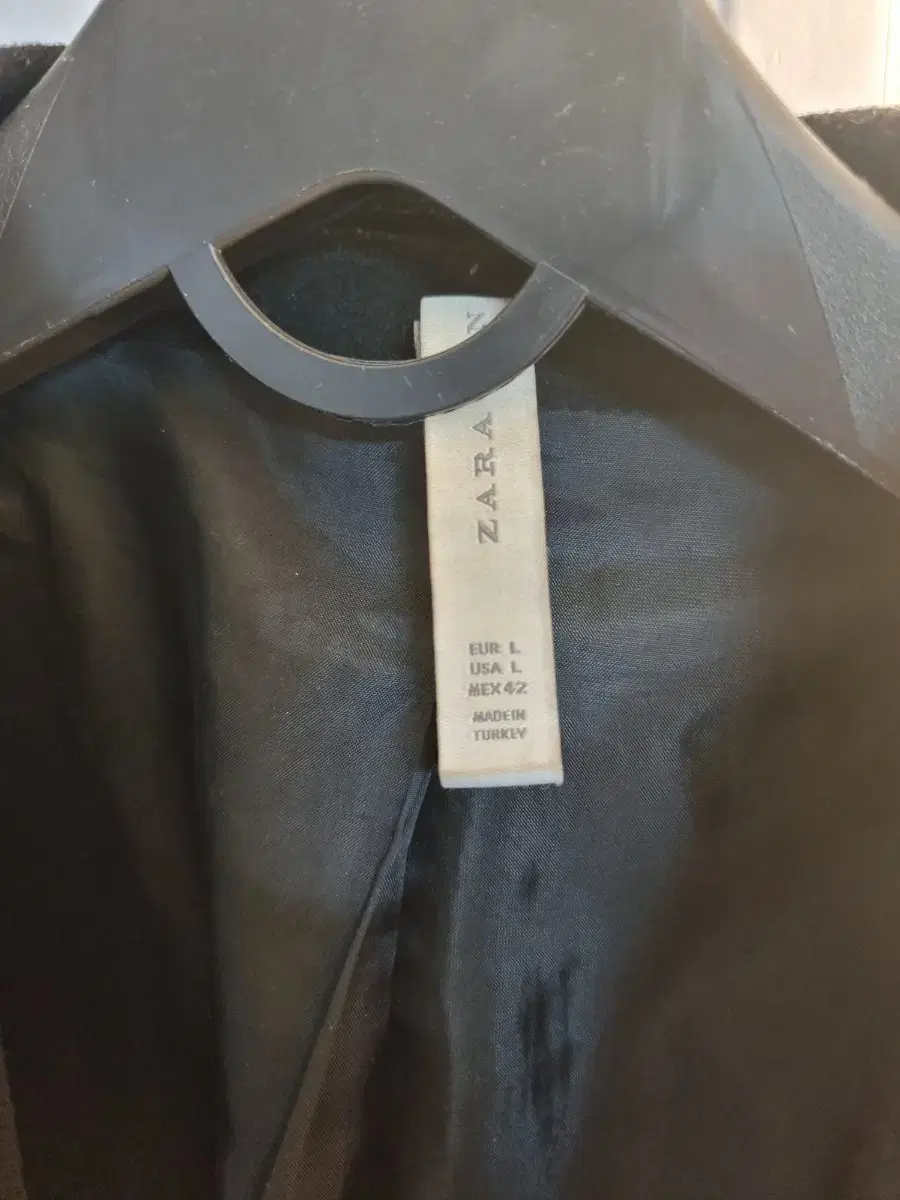 Zara sells men's black coats at a discount.