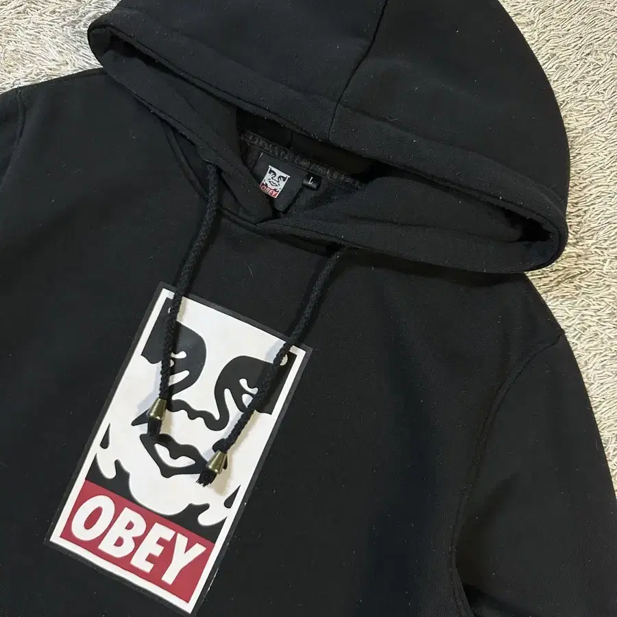 [L] 오베이 OBEY 페이스 로고 기능성 후드티 블랙