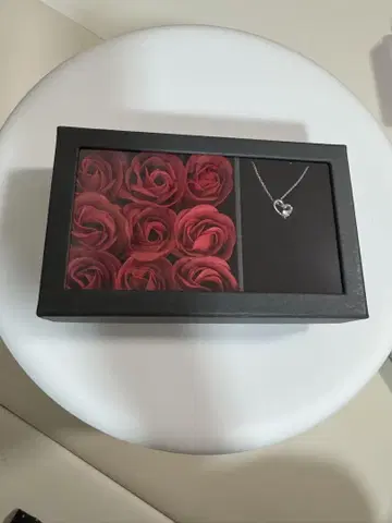 하트 모양의 펜던트와 빨간 장미 세트