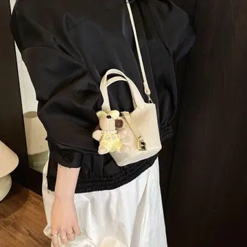 봉제 인형이 들어있는 화이트 미니 백