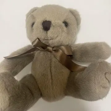 베이지 리본이 달린 곰 봉제 인형 앉을 수 있음