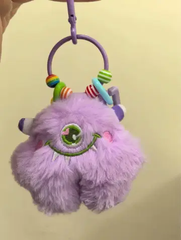 몬스터 자수가 있는 보라색 봉제 인형