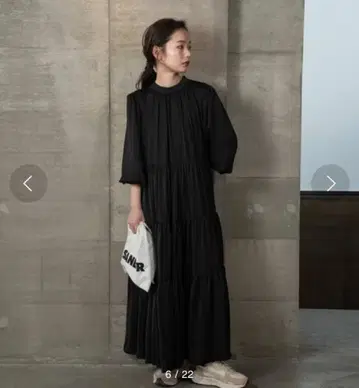 저는 높은 목선과 층층이 디자인의 블랙 티어드 오버올입니다.