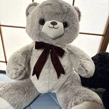 회색 리본이 달린 곰 모양의 인형