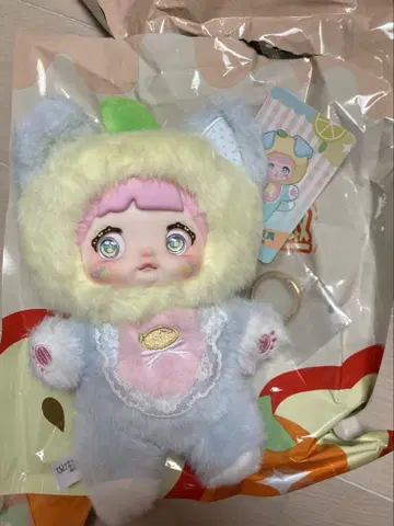 스카이블루와 옐로우 컬러의 봉제 인형 nommi