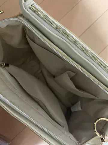 크림색 숄더백 삼각형 금장 장식 포함