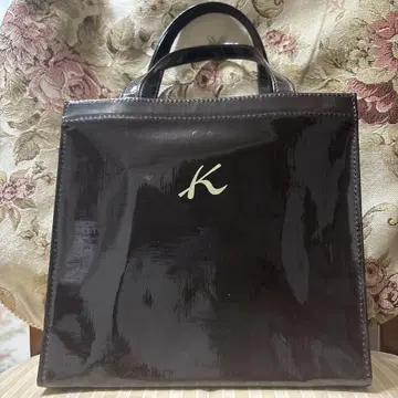 K 로고가 달린 짙은 갈색 토트백