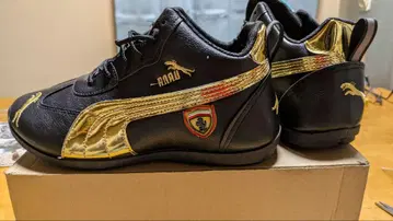 Puma 와 페라리 콜라보 블랙 골드와 Sport 슬립온 블랙