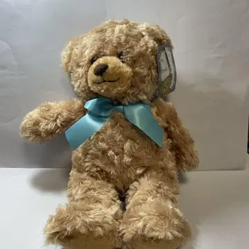 베이지색 리본 포함 봉제 인형