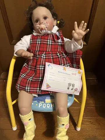 돌돌 말린 머리의 귀여운 여아 리본 인형