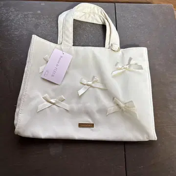 리본 장식 아이보리 핸드백