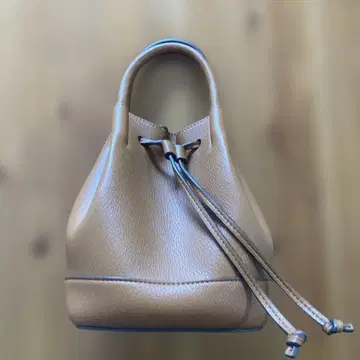 베이지 가죽 복조리형 핸드백 미라 오웬