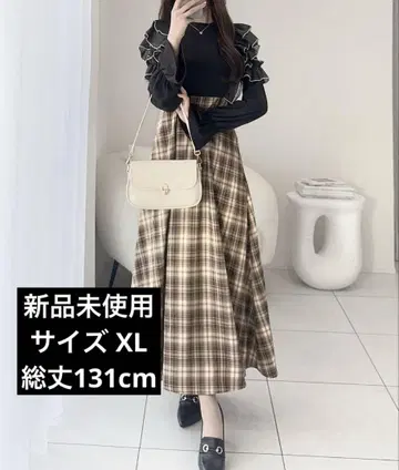 프릴이 달린 블랙 상의와 체크 롱 스커트