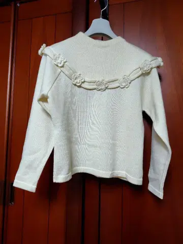 꽃 모티브가 달린 크림색 니트 스웨터