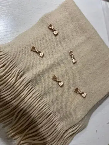 리본 모티브가 달린 베이지 머플러