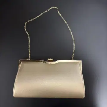 비쥬가 달린 골드 클러치백