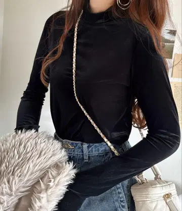 매끄럽고 광택 나는. 레이디를 돋보이게 하는 깔끔한 긴팔 터틀넥 멜로 탑