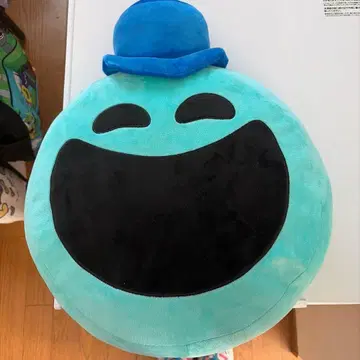 파란 모자를 쓴 웃는 얼굴 캐릭터 봉제 인형