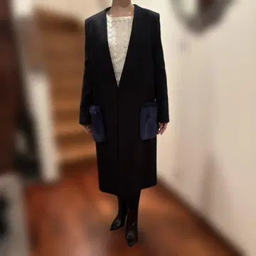 퍼가 달린 포켓의 블랙 롱 코트