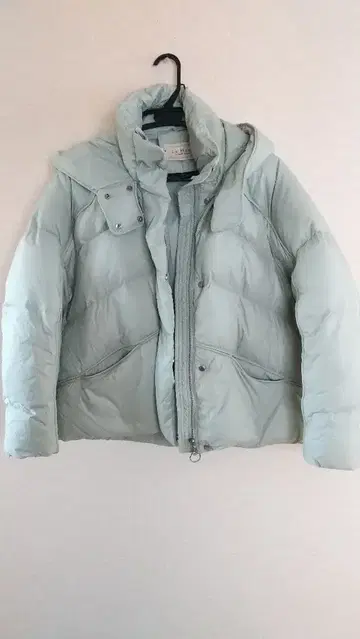 연한 하늘색 다운 재킷 후드 부착