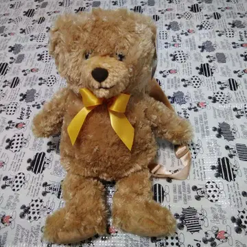 목둘레가 오렌지 컬러인 리본의 럭색 허니 테디베어 허니 팩입니다.