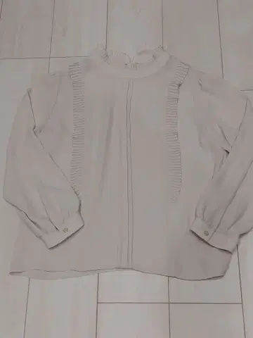 프릴이 달린 얇은 소재의 긴팔 블라우스 크림색