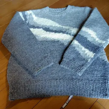 그레이 계열 스웨터. 파도처럼 사선으로 들어간 무늬가 특징