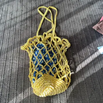 투모로우랜드 메쉬 디자인의 옐로우 컬러 핸드백