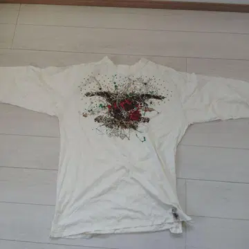 비즈가 달린 장미와 날개의 T셔츠