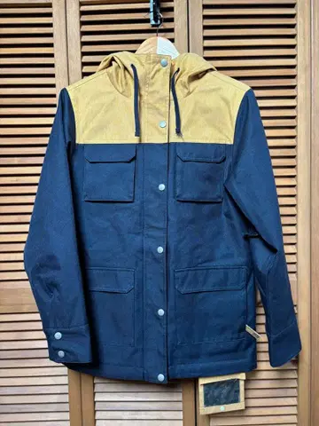 네이비와 베이지의 후드 부착 마운틴 파카