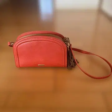 오렌지 태슬 부착 아치형 숄더백