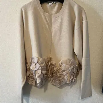 프릴이 달린 베이지색 긴팔 스웨터