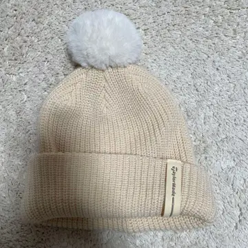 크림색 폼폼 포함 니트 비니