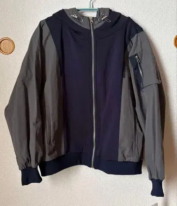 네이비와 그레이 색상의 후드 부착 자켓