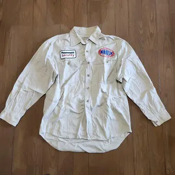 보안 로고가 있는 베이지색 긴팔 셔츠