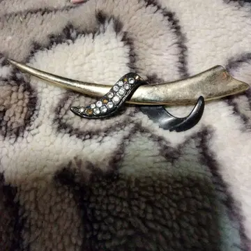 골드 컬러와 블랙 컬러의 곡선 브로치