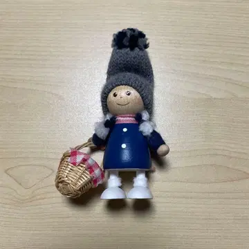 닛세 인형 바스켓을 든 파란 코트의 여아