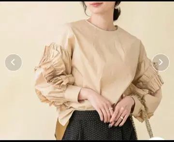 프릴이 달린 베이지색 긴팔 셔츠