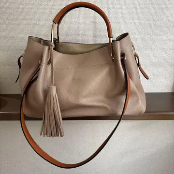 베이지 가죽 핸드백 태슬 포함